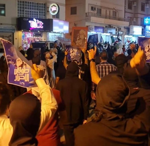 Participants in the Bilad Al-Qadeem march carrying pictures of Ayatollah Qassim and posters that read 